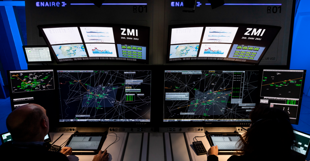 Controladores aéreos monitoreando el tráfico aéreo con sistemas automatizados en la pantalla de ENAIRE